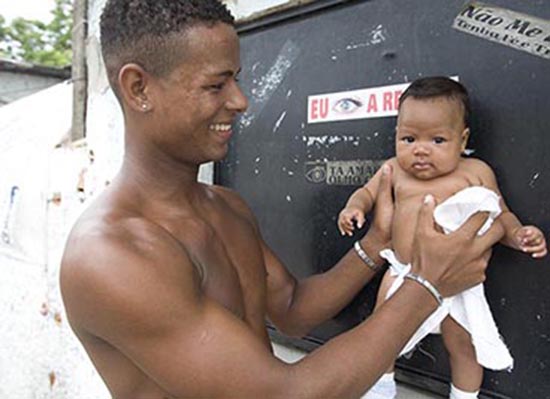 A father in Brazil smiles and holds his baby