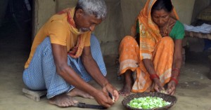 A grandfather participates in the preparation of food in Nepal.