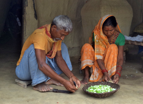 A grandfather participates in the preparation of food in Nepal.