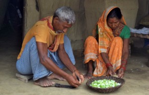 A grandfather participates in the preparation of food in Nepal.