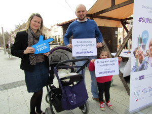 A father holds a sign that reads: "I change diapers daily." His daughter holds a sign that reads: "You listen to me and understand me."