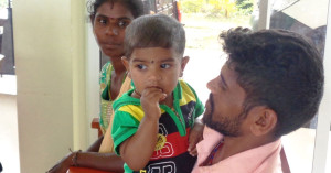 A father holds a child in his arms in Watawala ADP, Sri Lanka.