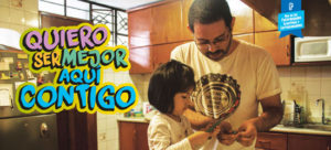 A father and child cook together in the kitchen. Text over the photo reads "Quiero ser mejor aquí contigo."