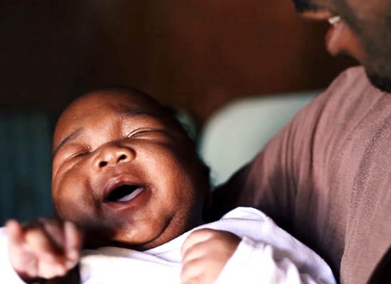Andrew holds his newborn in a still from "MenCare Short: South Africa."