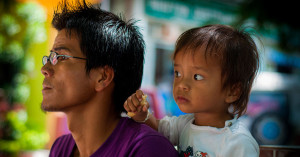 A father and child look into the distance.