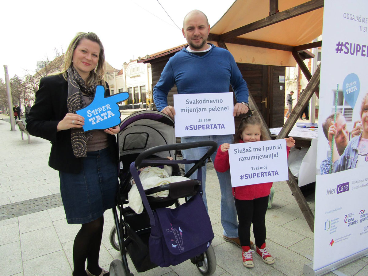 A father holds a sign that reads: “I change diapers daily.” His daughter holds a sign that reads: “You listen to me and understand me."