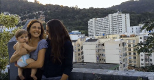 Carol and Kika holding their infant daughter Tereza in Rio de Janeiro.