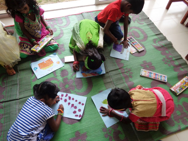 Children of MenCare participants gather together to create artwork.