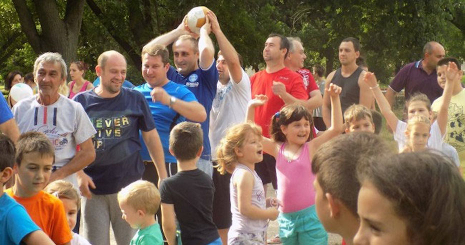 Fathers and children play outside.