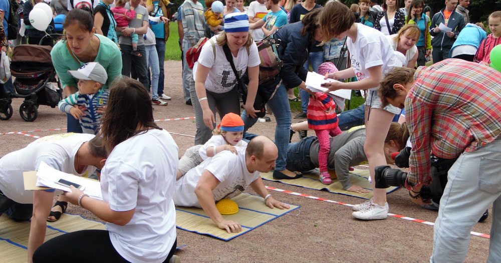 Parents and children play games outside.