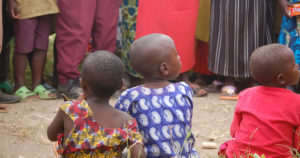 Three children sit with their backs to the camera.