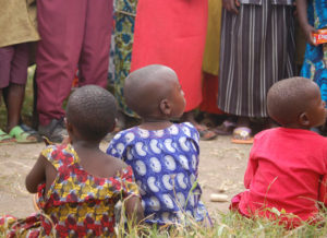 Three children sit with their backs to the camera.